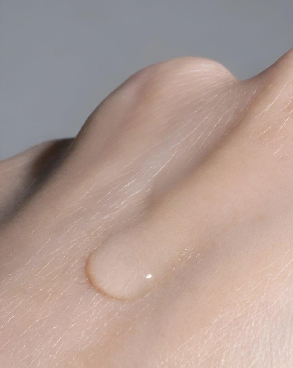 Drop of Eclat Soin Allergen Label-Free Micellar Cleansing Water on a person's hand, showcasing its lightweight texture